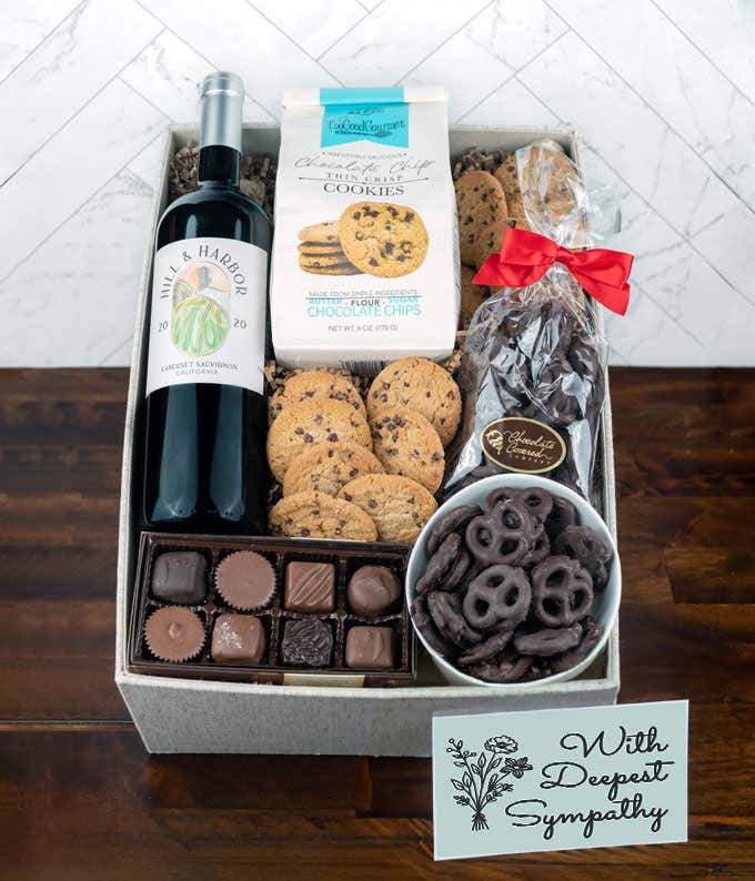 a gift box full of decadent treats with a Sympathy message card.  Contents include: a bottle of California Pinot Noir, a bag of milk chocolate pretzel, a box of mini chocolate chip cookies, and a 4-ounce box of assorted chocolates.