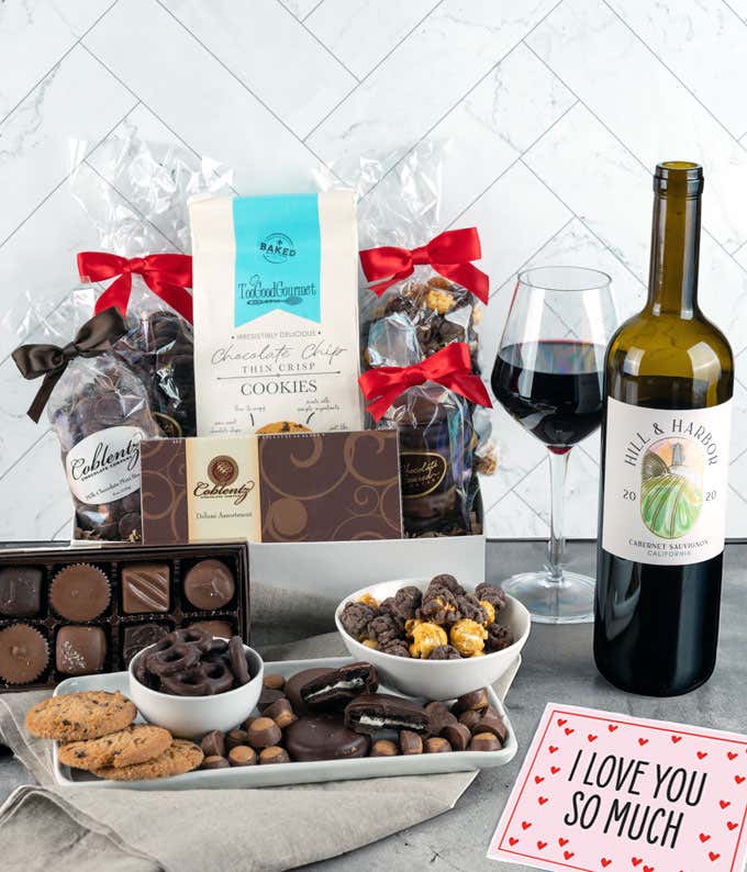 A gift set featuring a bottle of California Pinot Noir with chocolate pretzels, caramel popcorn, mini cookies, chocolate peanut butter buckeyes, chocolate-covered Oreos, assorted chocolates and an I Love You card.