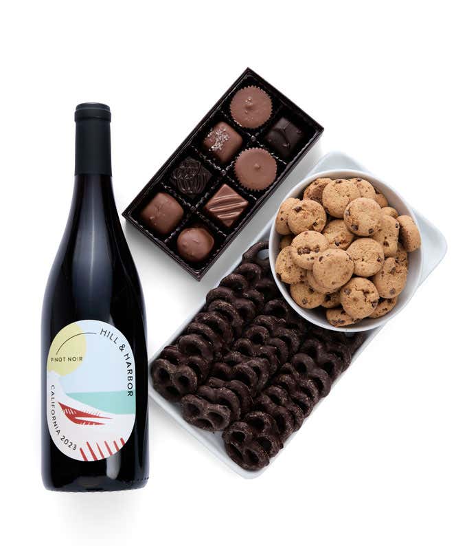 a gift box full of decadent treats.  Contents include: a bottle of California Pinot Noir, a bag of milk chocolate pretzel, a box of mini chocolate chip cookies, and a 4 ounce box of assorted chocolates.