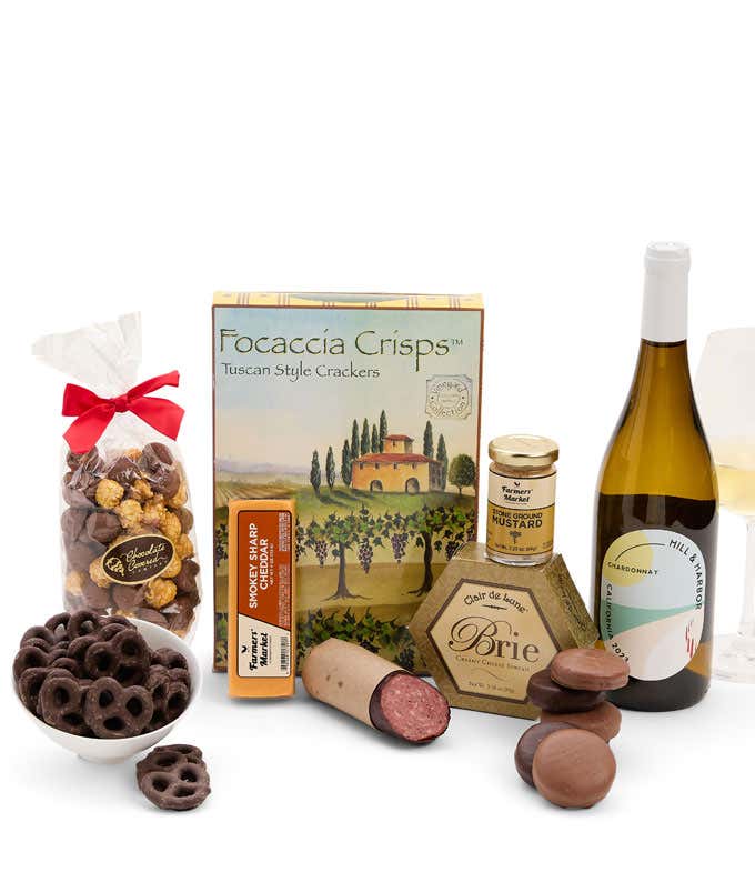 A gift set featuring a bottle of Hill & Harbor Chardonnay, focaccia crisps, 2 cheeses, mustard, summer sausage, caramel popcorn, chocolate pretzels, and 6 chocolate-covered Oreos for a sweet and savory gourmet experience.