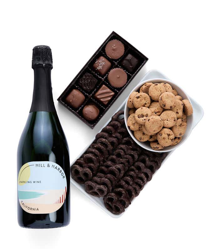 a gift box full of decadent treats.  Contents include: a bottle of California Sparkling Wine, a bag of milk chocolate pretzel, a box of mini chocolate chip cookies, and a 4-ounce box of assorted chocolates.