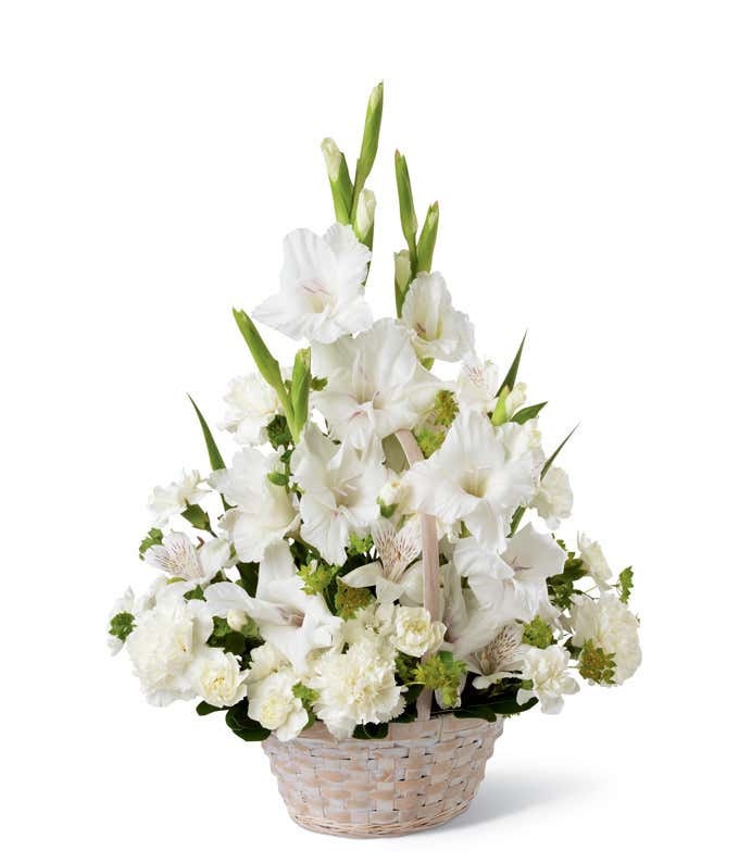 While gladiolus, alstroemeria, and carnations, with fresh greens arranged into a white floor basket