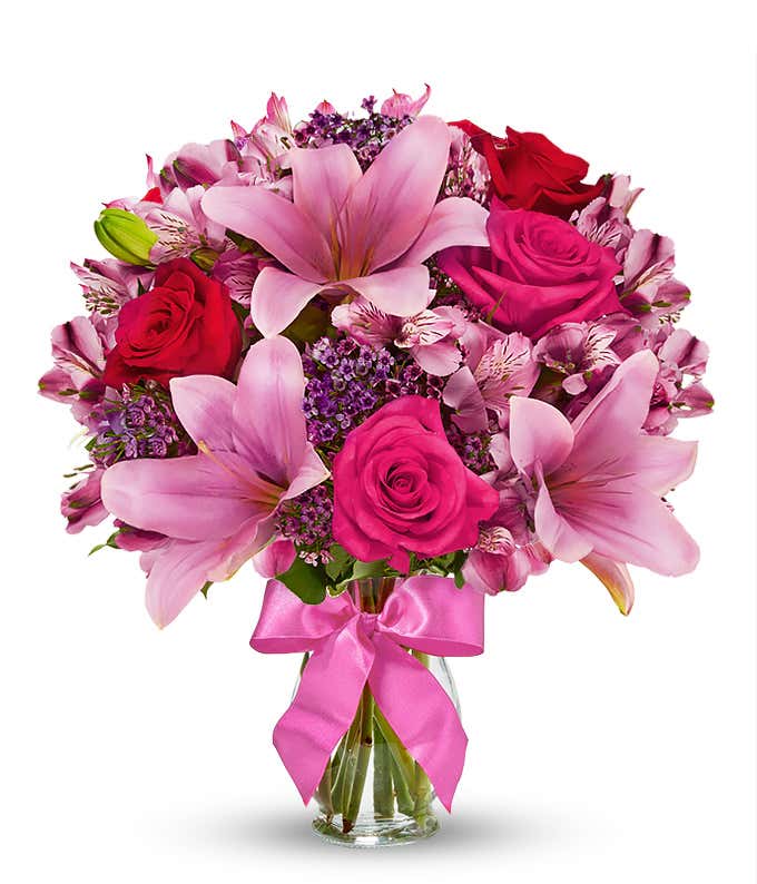 Red roses, pink lilies and pink alstroemeria and glass vase