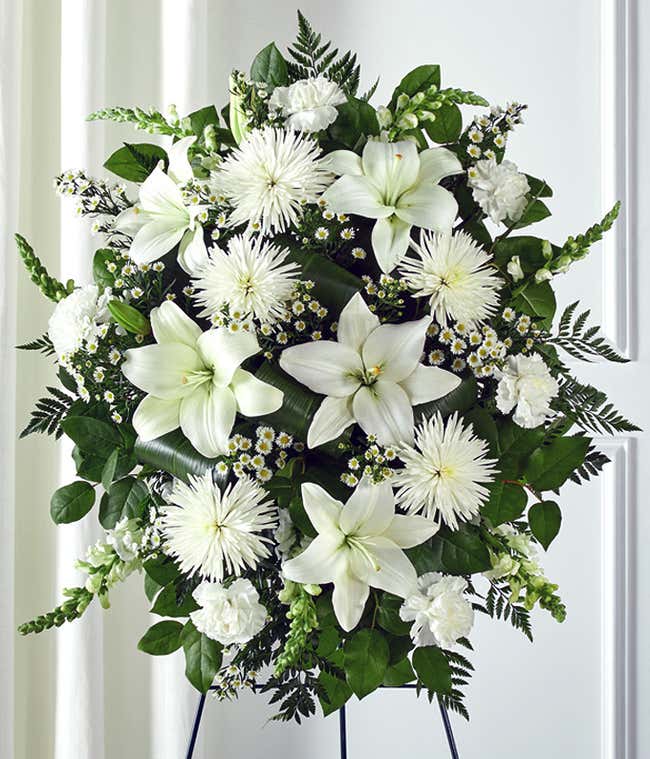 Funeral flowers with white lilies and white mums in standing spray