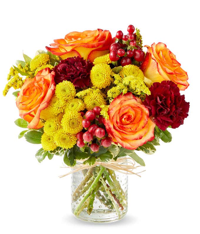 Yellow and orange daisies in pumpkin container