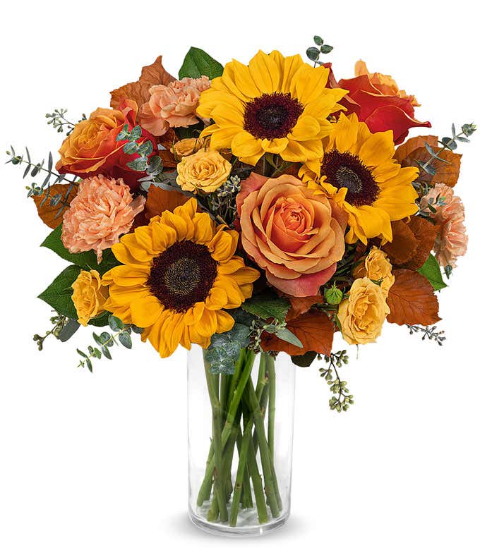 Orange and yellow roses, peach carnations, yellow sunflowers, brown copper beech, seeded & spiral eucalyptus, 