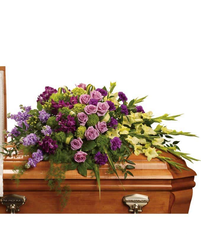 Tranquil casket spray featuring Green Miniature Hydrangea, Lavender Roses, Purple Alstroemeria, Green Gladioli, Green Trick, Purple Carnations, Lavender Stock, and Floral Greenery, a serene tribute to cherish.