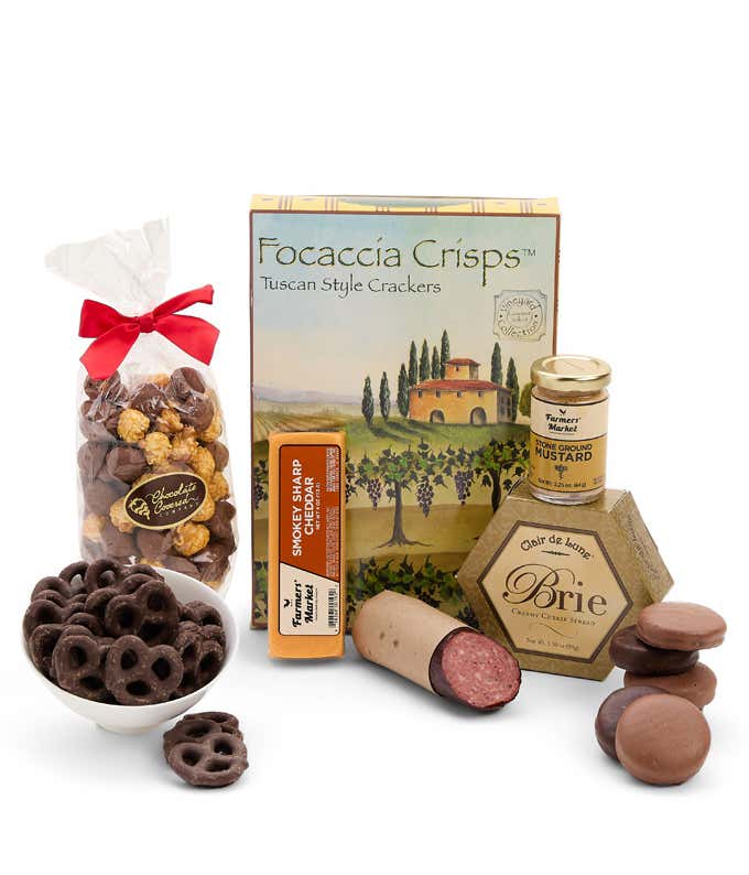 A gift box including focaccia crisps, two cheeses, mustard, brie cheese, summer sausage, chocolate-covered pretzels in a bowl, caramel popcorn, and six chocolate-covered Oreos for a sweet and savory gourmet experience.