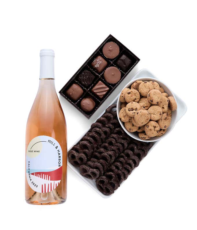 a gift box full of decadent treats.  Contents include: a bottle of California Ros wine, a bag of milk chocolate pretzel, a box of mini chocolate chip cookies, and a 4-ounce box of assorted chocolates.