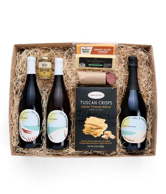 A gift box with three bottles of California wine (red, white, and sparkling), two types of cheese, crackers, stone-ground mustard, and a summer sausage.